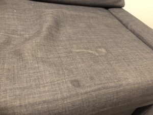 Old food stains embedded in couch fabric causing discoloration
