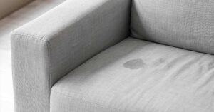 Body oil buildup causing dullness on couch fabric surface

