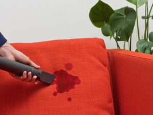 Old stain on a fabric couch where home cleaning may cause further damage
