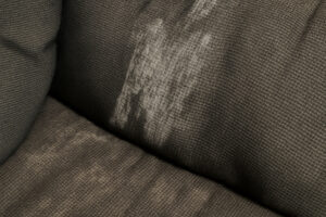 Couch fabric showing uneven liquid absorption after repeated cleaning
