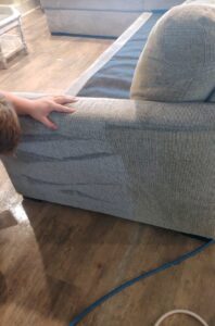 Couch fabric showing uneven wear and loss of protective coating
